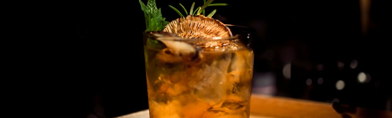 Cocktail ambrato con scorza di arancia, tipico di un aperitivo torinese